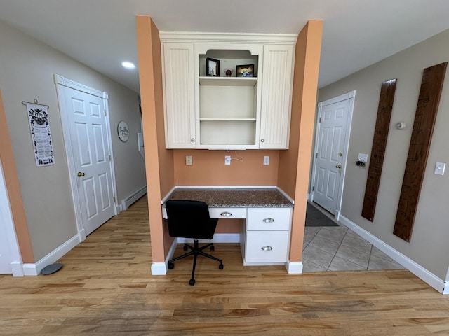 office area with light wood-style floors, baseboards, a baseboard heating unit, and built in study area