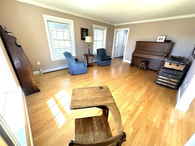 sitting room with baseboard heating, light wood finished floors, baseboards, a baseboard radiator, and ornamental molding