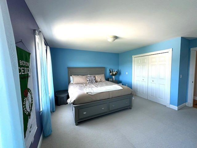 carpeted bedroom featuring baseboards and a closet