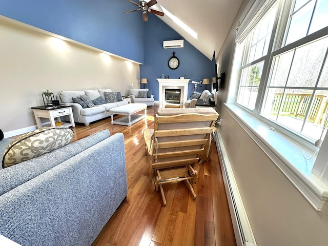 living room featuring a wall mounted air conditioner, a baseboard heating unit, a ceiling fan, and wood finished floors