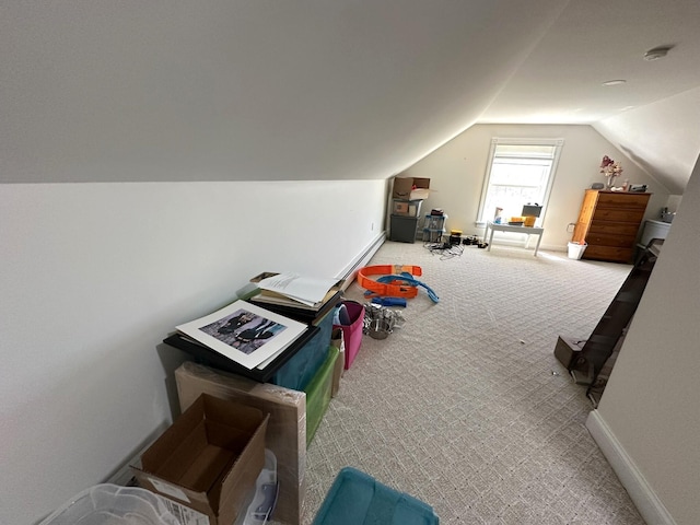 additional living space with baseboards, carpet, and vaulted ceiling
