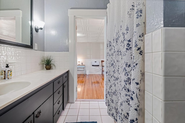 bathroom with tile patterned floors, vanity, and tile walls