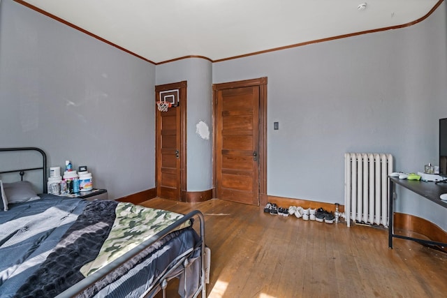 bedroom featuring radiator, crown molding, and hardwood / wood-style floors