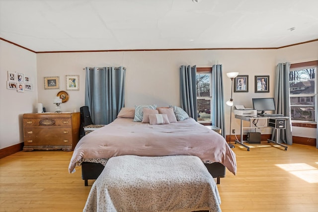 bedroom featuring light wood-type flooring, baseboards, ornamental molding, and multiple windows