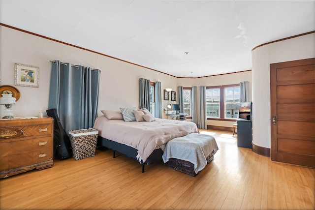 bedroom with crown molding and light wood-style floors