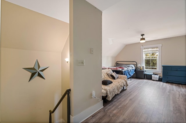 bedroom featuring wood finished floors, a ceiling fan, vaulted ceiling, and baseboards