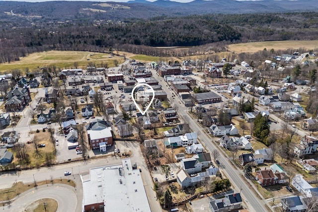 birds eye view of property with a wooded view, a mountain view, and a residential view