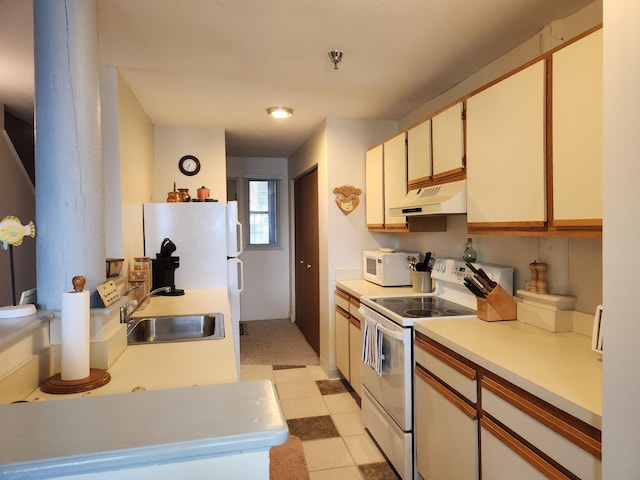 kitchen featuring a sink, light countertops, under cabinet range hood, white appliances, and light tile patterned flooring