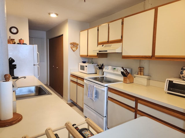 kitchen with light countertops, a toaster, a sink, under cabinet range hood, and white appliances