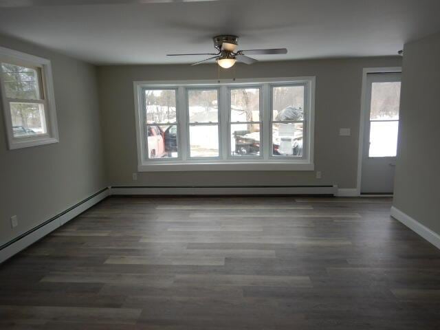 empty room featuring ceiling fan, baseboards, and dark wood-type flooring