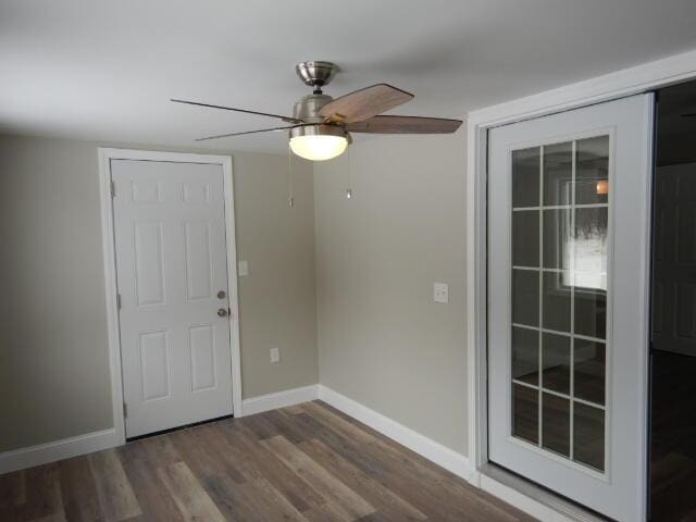 interior space with a ceiling fan, wood finished floors, and baseboards