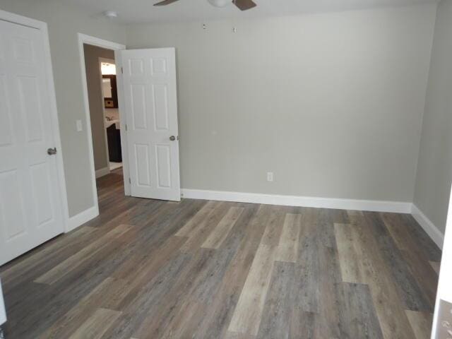 unfurnished room featuring baseboards, wood finished floors, and a ceiling fan