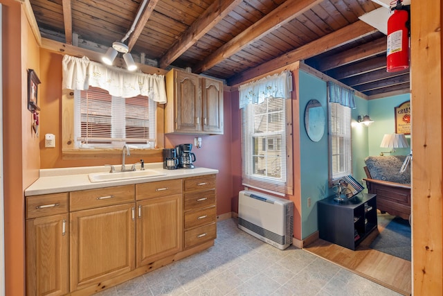 kitchen featuring a sink, wooden ceiling, light countertops, beamed ceiling, and baseboards