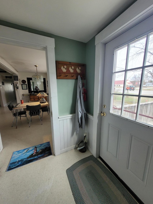 mudroom featuring a chandelier, wainscoting, and carpet floors
