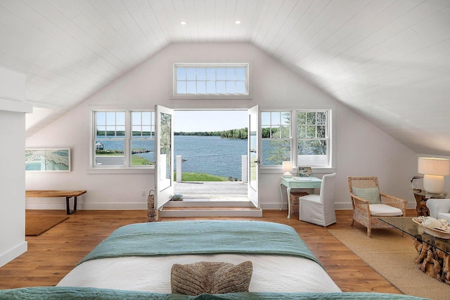 bedroom featuring baseboards, wood finished floors, a water view, and lofted ceiling
