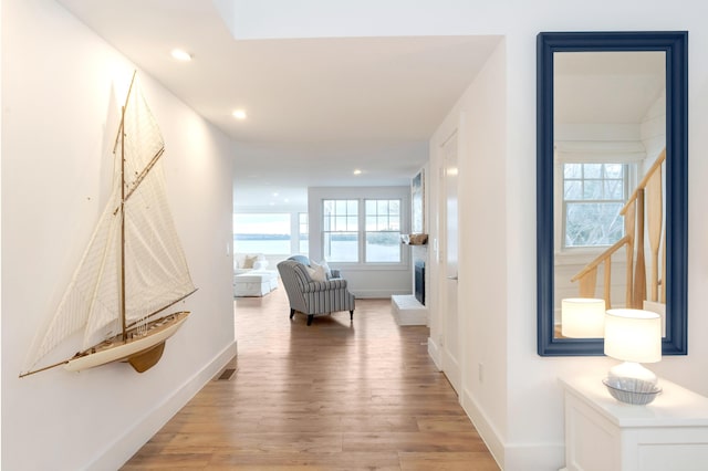corridor with visible vents, light wood-type flooring, recessed lighting, and baseboards