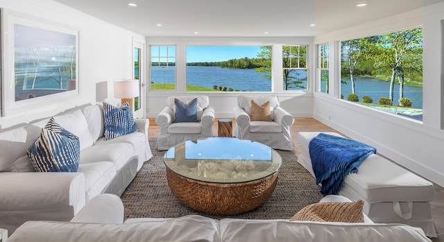 sunroom featuring wood finished floors, recessed lighting, and a water view