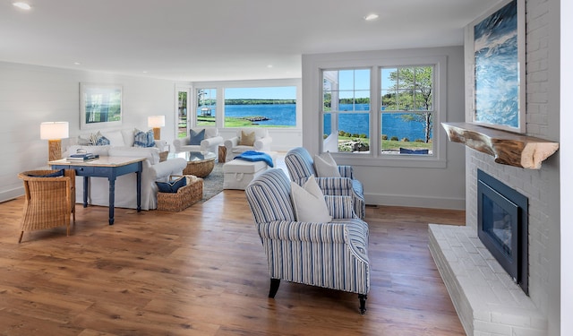 living room with a wealth of natural light, wood finished floors, and a fireplace