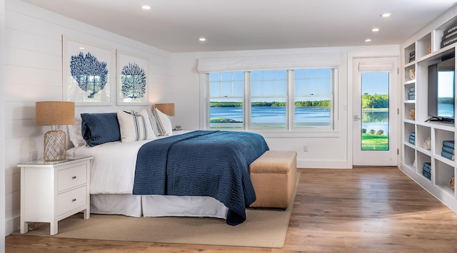 bedroom featuring recessed lighting, wood finished floors, and access to exterior