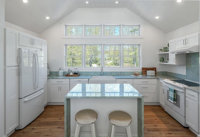 kitchen featuring white appliances, recessed lighting, under cabinet range hood, and a sink