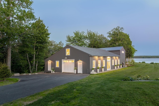 garage featuring aphalt driveway and a water view
