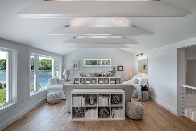 living area featuring wood finished floors, vaulted ceiling with beams, and baseboards