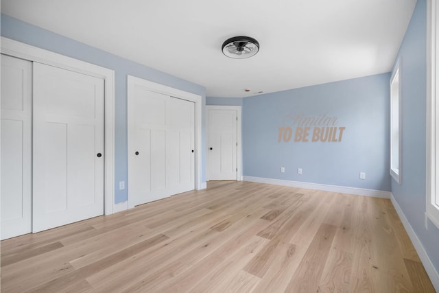 4-16 Tatnic Rd, Wells, ME 04090 - unfurnished bedroom with light wood-style floors, baseboards, and multiple closets
