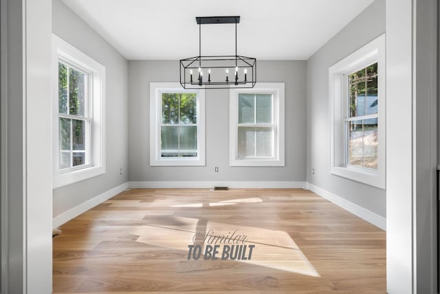 4-16 Tatnic Rd, Wells, ME 04090 - unfurnished dining area with plenty of natural light, light wood-style flooring, baseboards, and a notable chandelier