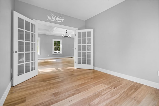 4-16 Tatnic Rd, Wells, ME 04090 - empty room featuring coffered ceiling, baseboards, french doors, and a notable chandelier
