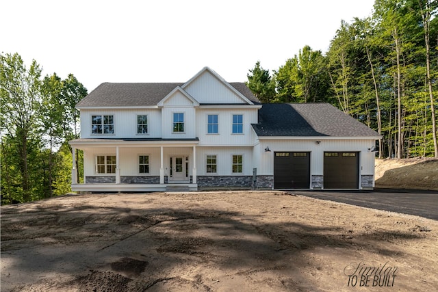 4-16 Tatnic Rd, Wells, ME 04090 - view of front of property with covered porch, an attached garage, stone siding, driveway, and a shingled roof