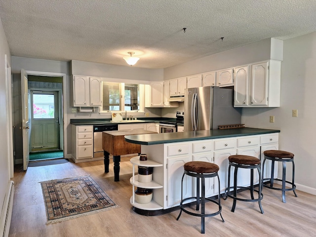 31 Arbor Ave, Topsham, ME 04086 - kitchen featuring appliances with stainless steel finishes, dark countertops, a peninsula, under cabinet range hood, and a textured ceiling