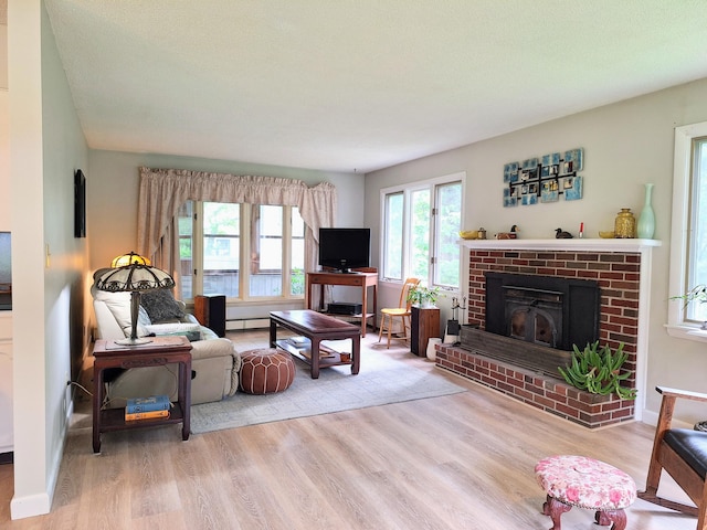 31 Arbor Ave, Topsham, ME 04086 - living area featuring wood finished floors, a baseboard radiator, and a brick fireplace