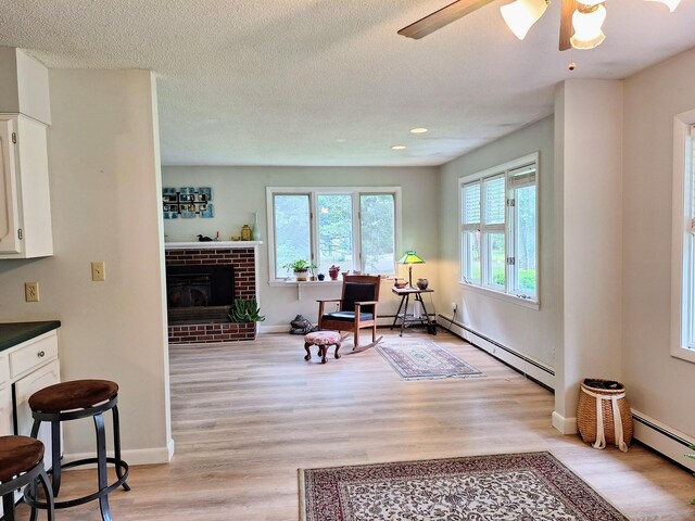 31 Arbor Ave, Topsham, ME 04086 - living room featuring light wood-style floors, a baseboard heating unit, a ceiling fan, a fireplace, and recessed lighting