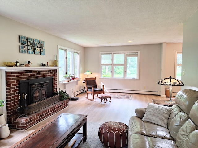 31 Arbor Ave, Topsham, ME 04086 - living area with a baseboard heating unit, wood finished floors, a textured ceiling, and a fireplace