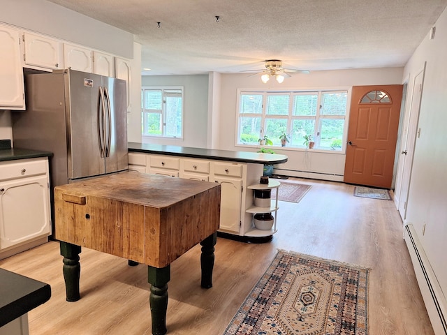 31 Arbor Ave, Topsham, ME 04086 - kitchen with a baseboard radiator, freestanding refrigerator, dark countertops, a peninsula, and a textured ceiling