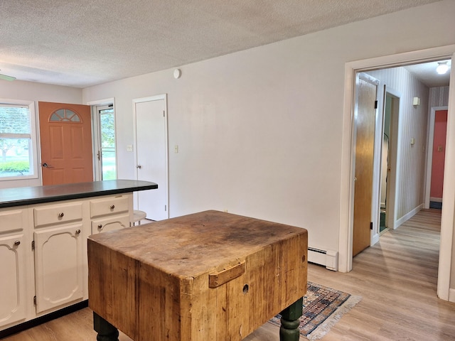31 Arbor Ave, Topsham, ME 04086 - kitchen featuring dark countertops, a textured ceiling, baseboard heating, light wood-style floors, and white cabinets