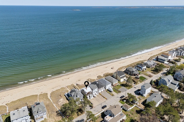drone / aerial view featuring a beach view, a residential view, and a water view
