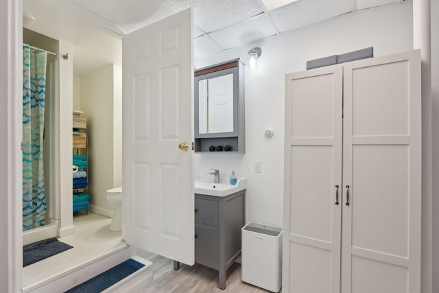 bathroom with wood finished floors, vanity, baseboards, toilet, and a shower with shower curtain