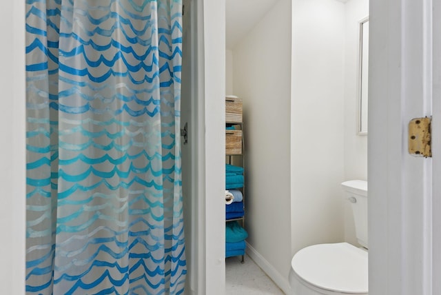 bathroom with baseboards, curtained shower, and toilet