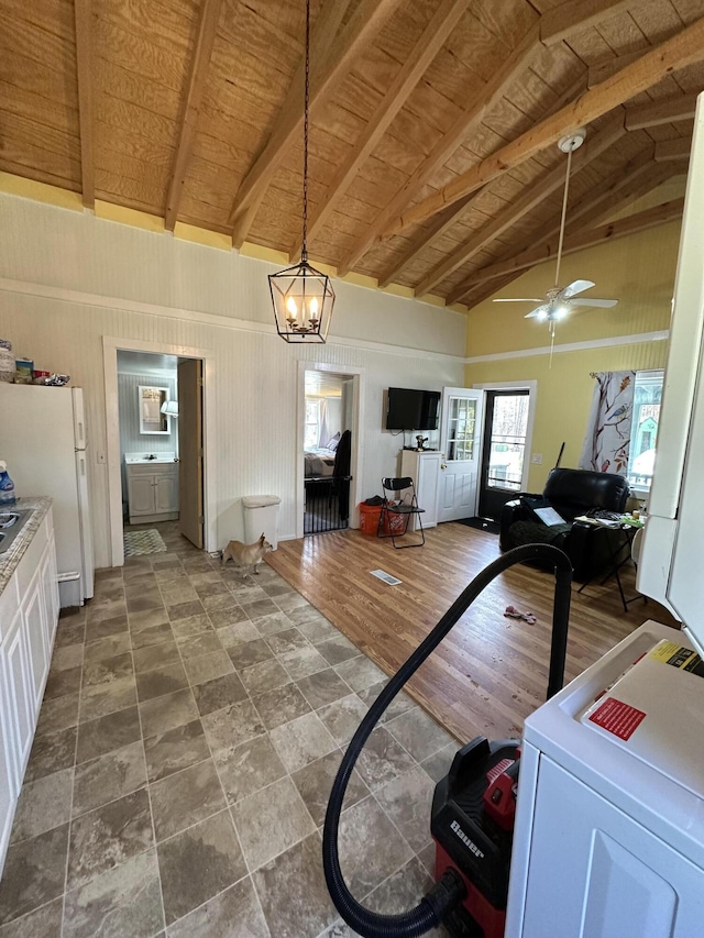 interior space with lofted ceiling with beams, wood ceiling, and ceiling fan with notable chandelier
