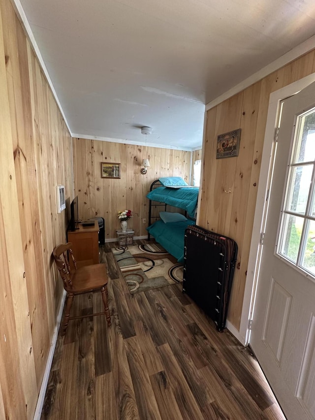 interior space featuring baseboards, wood finished floors, and wooden walls