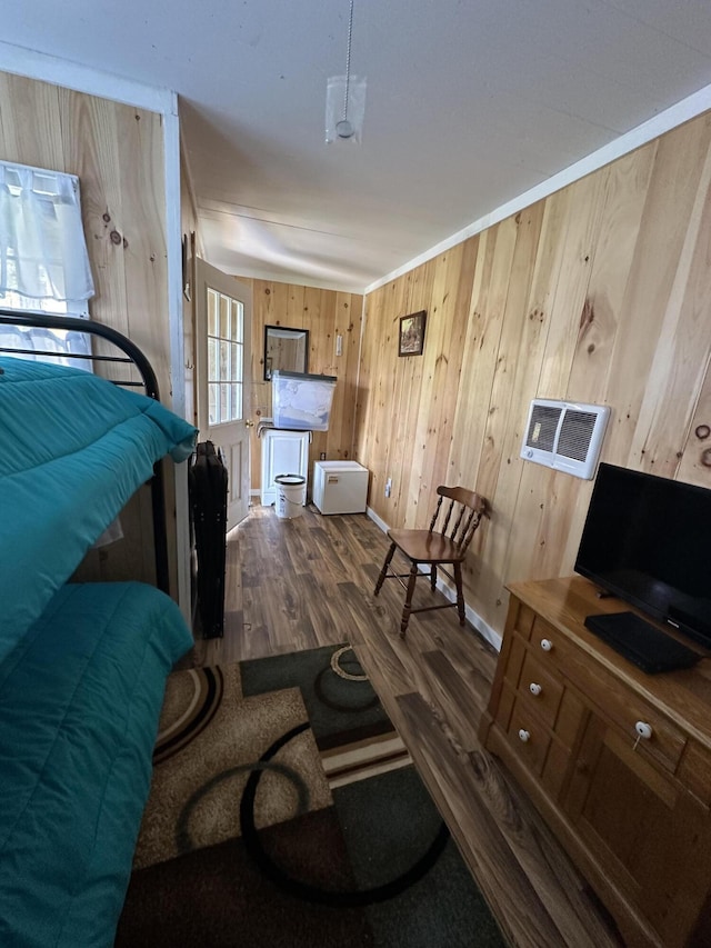 bedroom featuring wooden walls, baseboards, and dark wood-style floors