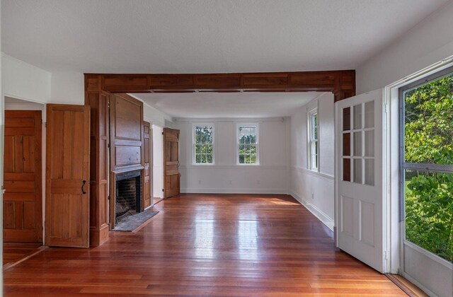 258 River Rd, Eliot, ME 03903 - unfurnished living room with a large fireplace and hardwood / wood-style floors