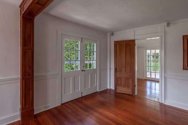 258 River Rd, Eliot, ME 03903 - entrance foyer featuring a textured ceiling, a decorative wall, and wood finished floors