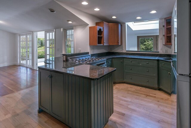 258 River Rd, Eliot, ME 03903 - kitchen featuring a peninsula, a skylight, light wood-style flooring, and green cabinetry