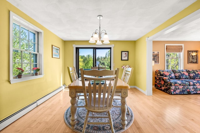 31 Saltwater Dr, York, ME 03909 - dining space with a baseboard radiator, a chandelier, plenty of natural light, and wood-type flooring