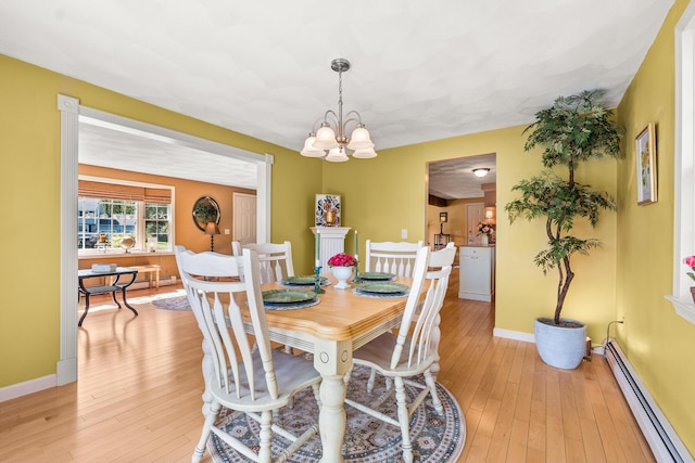 31 Saltwater Dr, York, ME 03909 - dining room featuring a baseboard radiator, light wood-type flooring, a chandelier, and baseboards