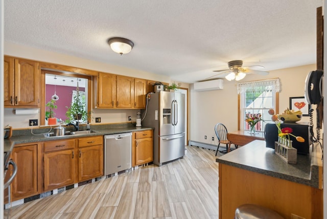 171 Regan Ln, Portland, ME 04103 - kitchen with appliances with stainless steel finishes, a wall unit AC, a baseboard heating unit, a sink, and brown cabinets