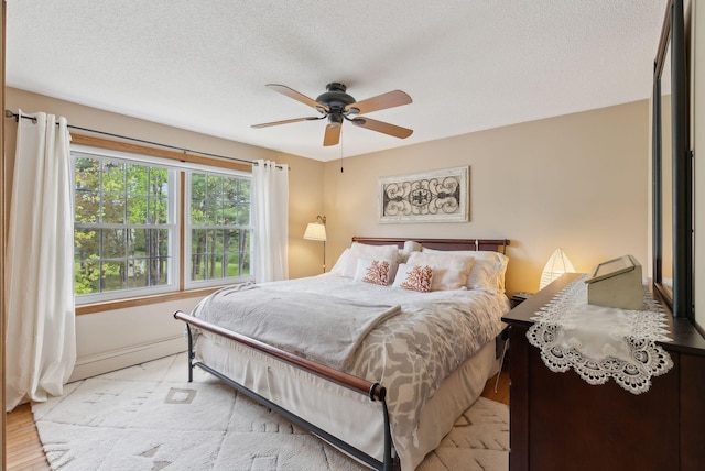 171 Regan Ln, Portland, ME 04103 - bedroom with a textured ceiling, baseboards, a ceiling fan, and light wood-type flooring