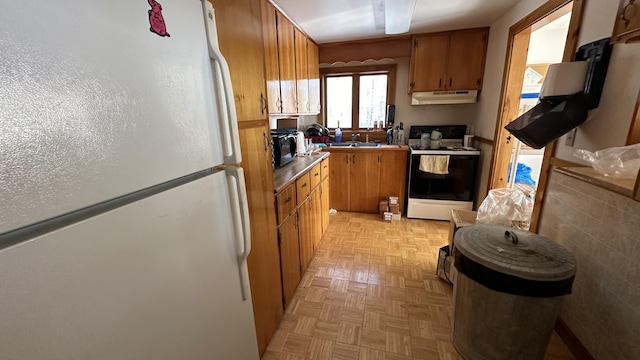 1057 Back Brooks Rd, Monroe, ME 04951 - kitchen featuring a sink, freestanding refrigerator, brown cabinetry, electric range oven, and under cabinet range hood